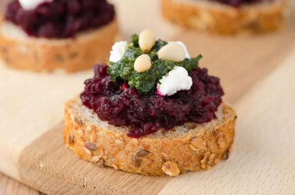 Salada de beterraba com pesto e queijo de cabra em pães de cereais torrados — Fotografia de Stock