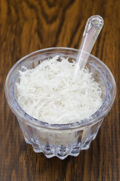 Unsweetened coconut flakes in a transparent jar — Stock Photo, Image