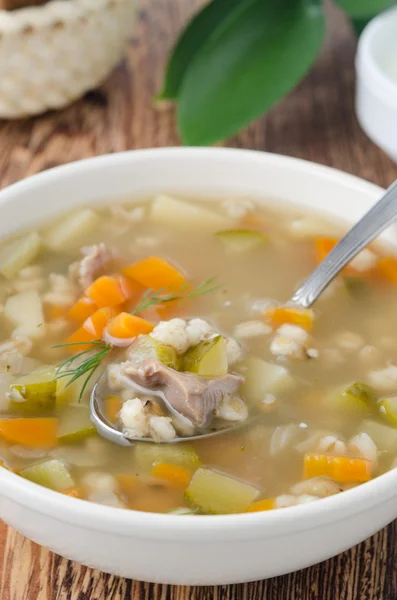 Русский суп рассолник в белой миске, ложка супа крупным планом — стоковое фото