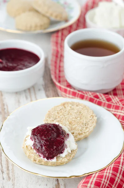 Scone with goat cheese and jam for breakfast — Stock Photo, Image