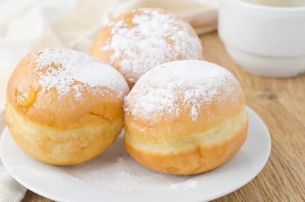 Three sweet donuts sprinkled with powdered sugar — Stock Photo, Image