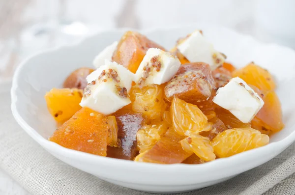Salad with persimmon, mandarin oranges and goat cheese closeup — Stock Photo, Image