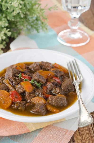 Stew of beef with vegetables and prunes in a plate, vertical — Stock Photo, Image