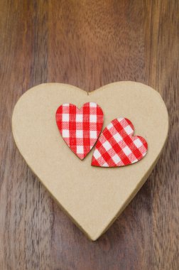 Decorative gift box with hearts on a wooden background
