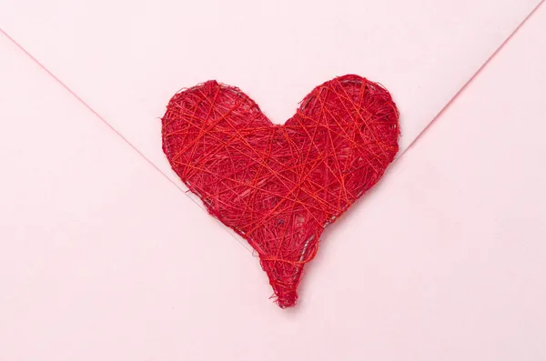 Corazón rojo en un sobre rosa — Foto de Stock