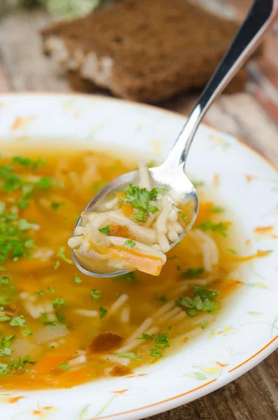 Sendok sup ayam dengan mie dan wortel closeup vertikal — Stok Foto