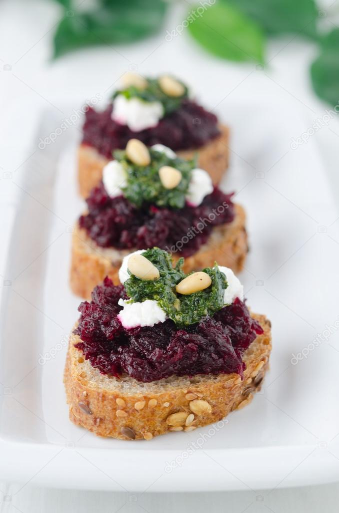 Beet salad with pesto and goat cheese on toasted grain breads