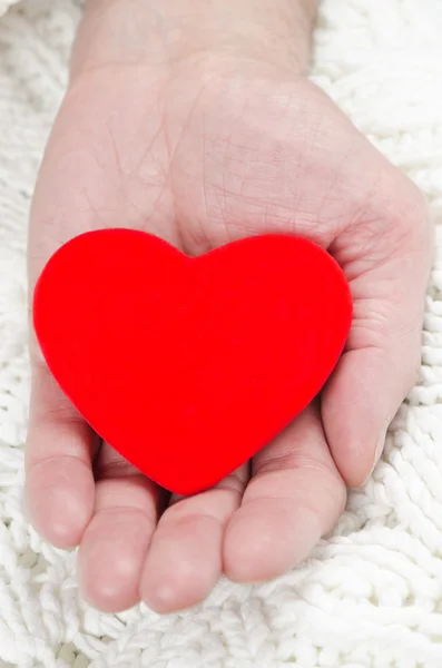 Coração vermelho na palma da mão de um homem — Fotografia de Stock