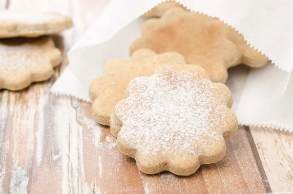 Biscotti immaginati spruzzati con zucchero a velo in un sacchetto di carta sel — Foto Stock