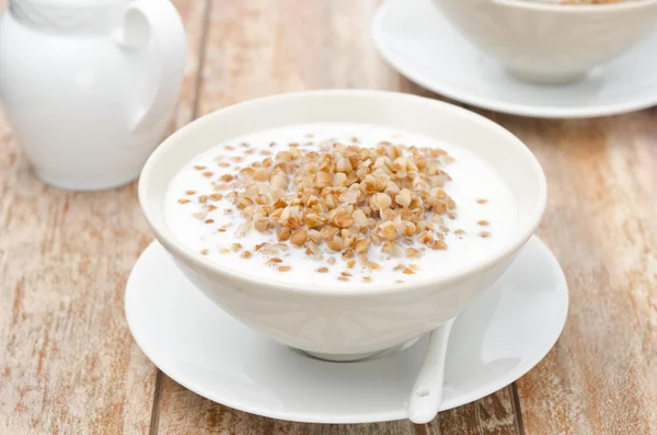 Gekochter Buchweizen mit Milch in einer weißen Schüssel horizontal — Stockfoto