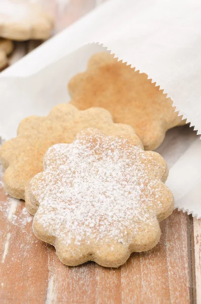 Biscuits figurés saupoudrés de sucre en poudre dans un sac en papier — Photo