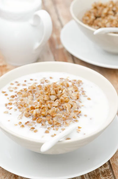 Trigo sarraceno hervido con leche en un tazón blanco, primer plano — Foto de Stock