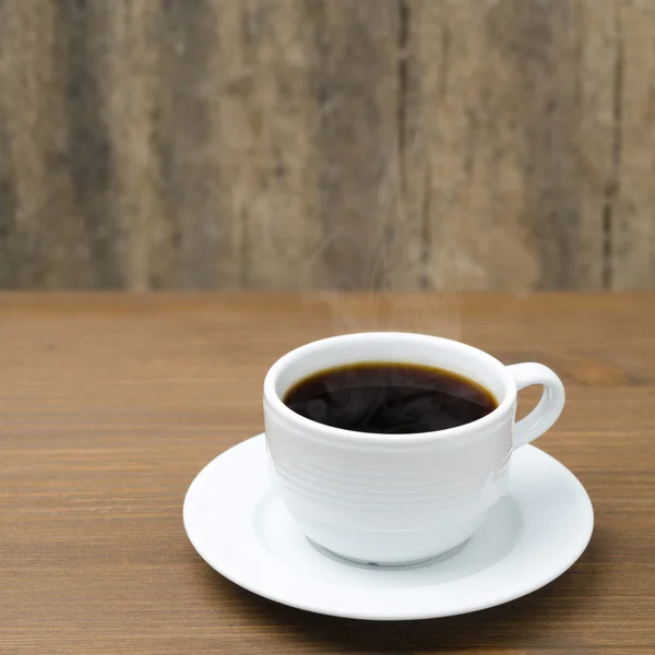 Taza de café con vapor en una mesa de madera — Foto de Stock