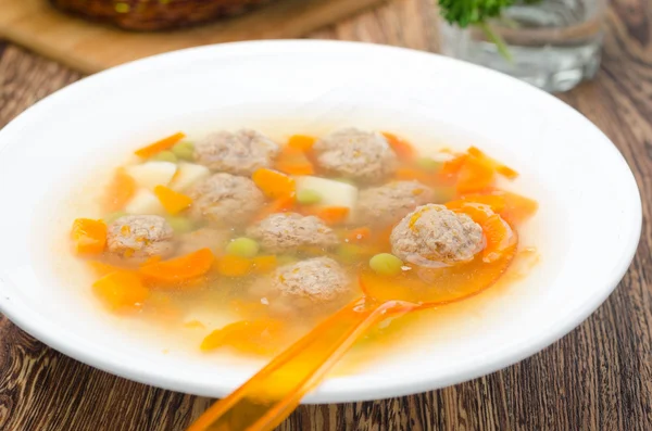 Vegetable soup with chicken meatballs with orange spoon — Stock Photo, Image