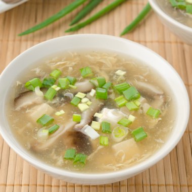 Chinese spicy soup with egg, shiitake mushrooms, tofu and green clipart
