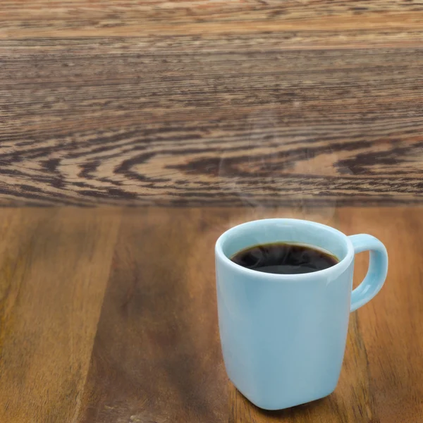 Šálek černé kávy na dřevěný stůl — Stock fotografie