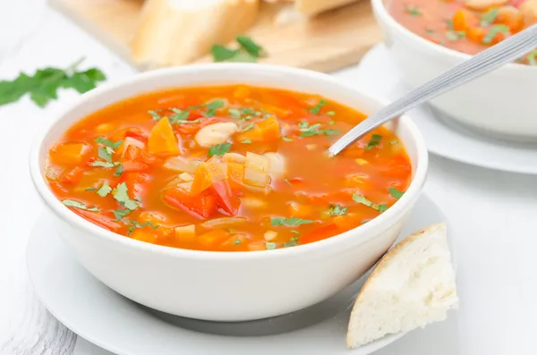 Vegetable soup with white beans in a bowl and spoon horizontal — Stock Photo, Image