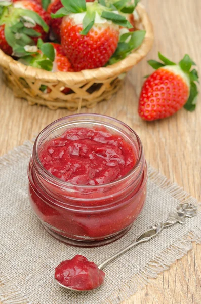 Mermelada de fresa en un frasco de vidrio y fresas frescas — Foto de Stock