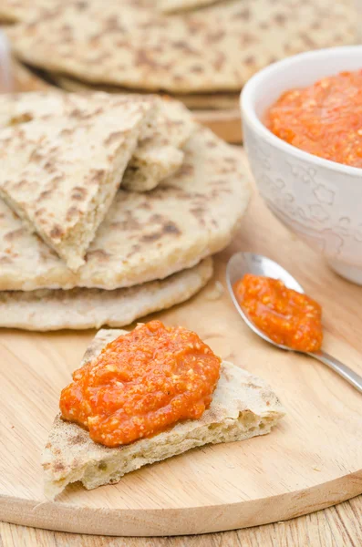 Roasted pepper dip with almonds, garlic on a piece of bread — Stock Photo, Image