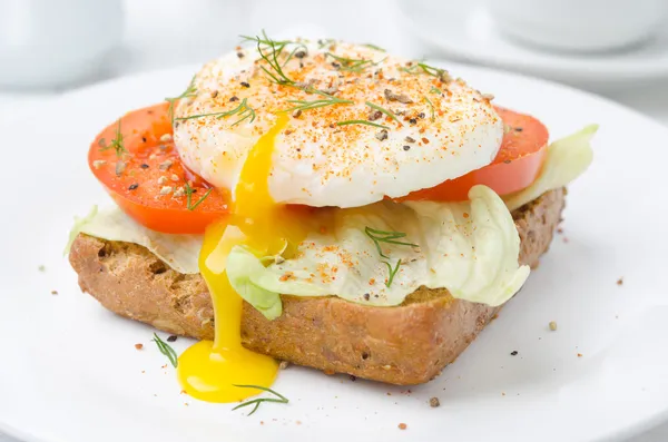 Toast cu roșii, salată verde și ouă braconate pentru micul dejun closeup — Fotografie de stoc gratuită