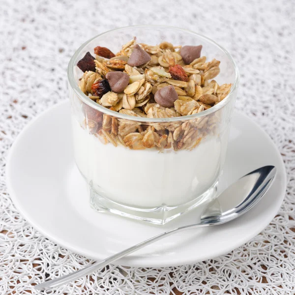 Yoghurt en muesli met chocolade druppels in een bekerglas van glas — Stockfoto