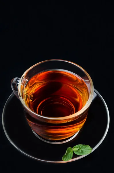 Tasse schwarzen Tee mit Minze auf schwarzem Hintergrund von oben — Stockfoto