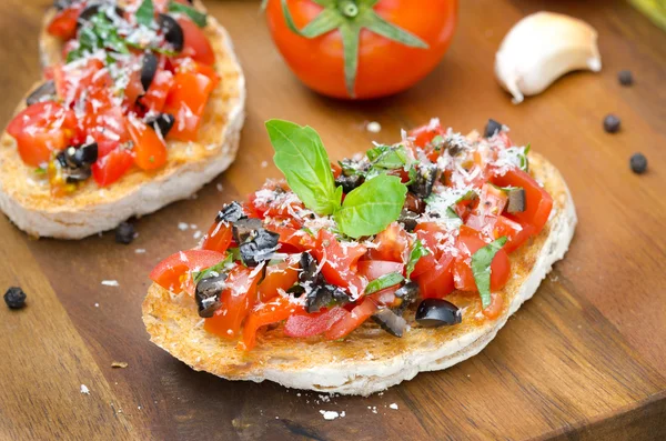 Italian bruschetta with tomato, olives, basil and cheese — Stock Photo, Image