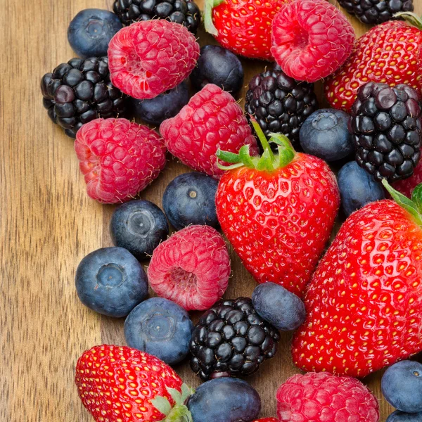 Assorted berries on wooden background — Stock Photo, Image