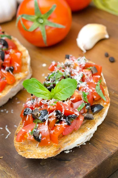 Bruschetta italiana con tomate, aceitunas, albahaca y queso —  Fotos de Stock