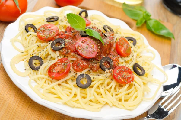 Спагетті з томатним соусом, вишневими помідорами та оливками — стокове фото