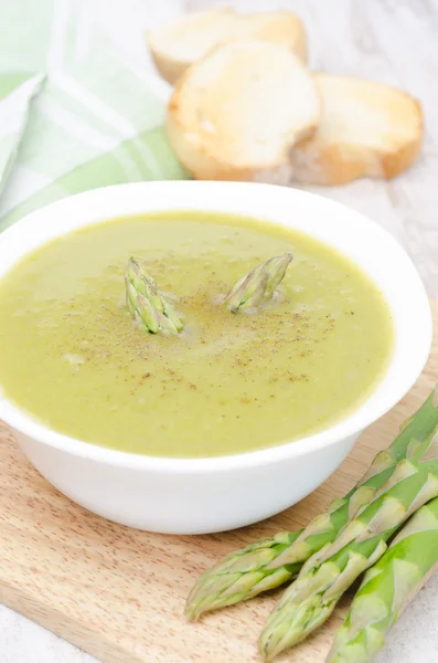 Sup krim asparagus dan kacang polong hijau dalam mangkuk dengan roti panggang — Stok Foto