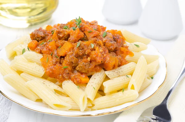 Penne pasta met saus van rundvlees, tomaat en pompoen close-up — Stockfoto