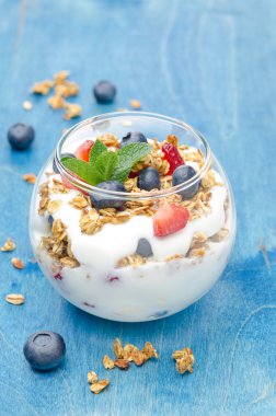 tatlı yoğurt, granola, bir bardak taze çilek ile katmanlı