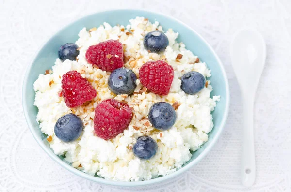 Bowl of cottage cheese with berries, honey, nuts for breakfast — Stock Photo, Image