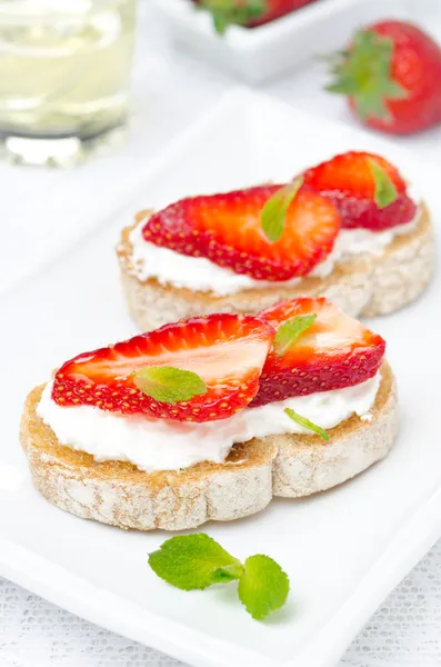 Bruschetta mit Ziegenkäse, frischen Erdbeeren, Minze und Honig — Stockfoto