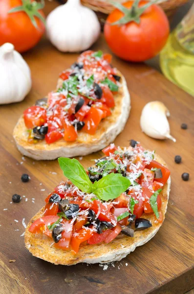 Bruschetta italiana con tomate, aceitunas, albahaca y queso —  Fotos de Stock