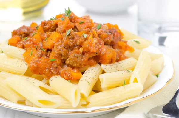 Penne pasta with sauce of beef, tomato and pumpkin on a plate — Stock Photo, Image