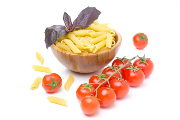 Makaron penne, świeżymi pomidorami i bazylią na białym tle — Zdjęcie stockowe