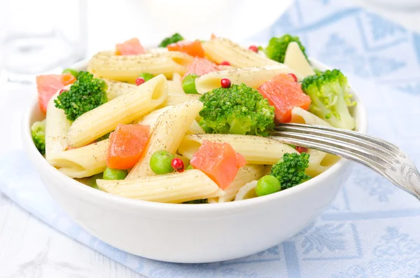 Ensalada con pasta, salmón ahumado, broccol, guisantes verdes en un bol —  Fotos de Stock