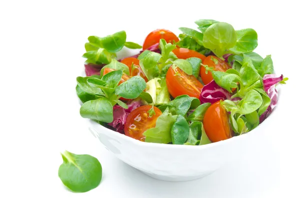 Miska, świeże sałatki i pomidorkami na białym tle — Zdjęcie stockowe