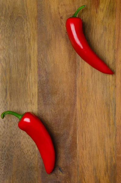 Dřevěné pozadí s red hot chili papričky — Stock fotografie