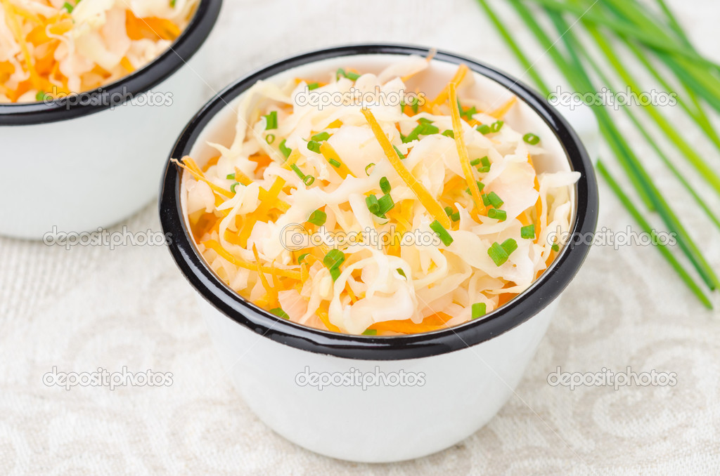 Salad of pickled cabbage with carrots and green onions close-up