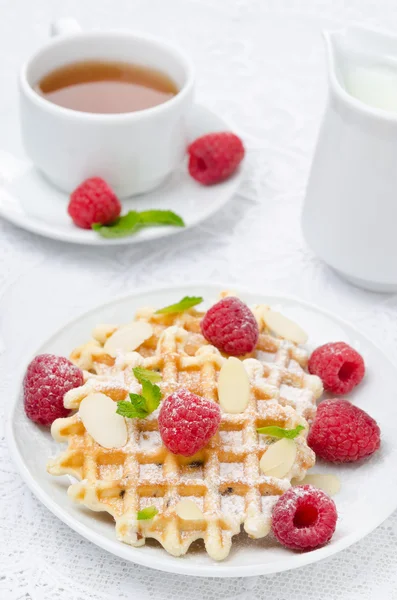 Waffles with fresh raspberries, nuts and tea for breakfast Royalty Free Stock Photos