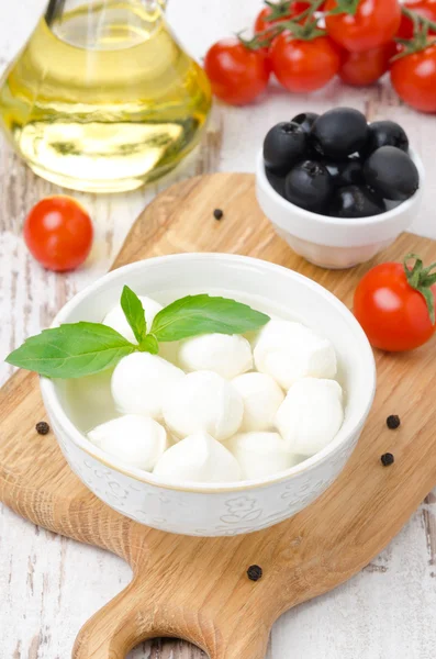 Färsk mozzarella i en skål, oliver och körsbärstomater — Stockfoto