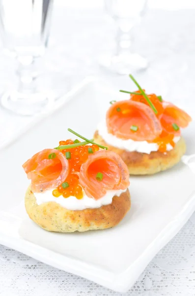 Pão de batata com salmão salgado, caviar vermelho e cebolinha, vertical — Fotografia de Stock