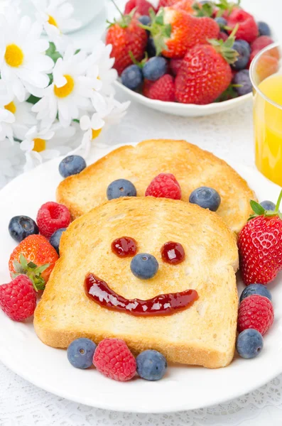 Frühstück mit einem lächelnden Toast, frischen Beeren und Orangensaft — Stockfoto