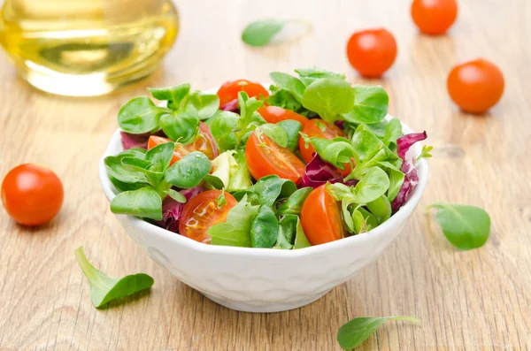 Fresh salad and cherry tomatoes in a bowl, olive oil — Stock Photo, Image