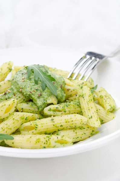 意大利面通心粉酱板上的芝麻菜和绿豌豆 — 图库照片