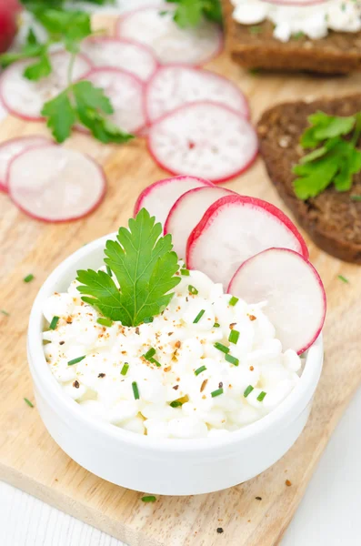 Queijo cottage macio com rabanete e cebolinha em uma tigela, vertical — Fotografia de Stock