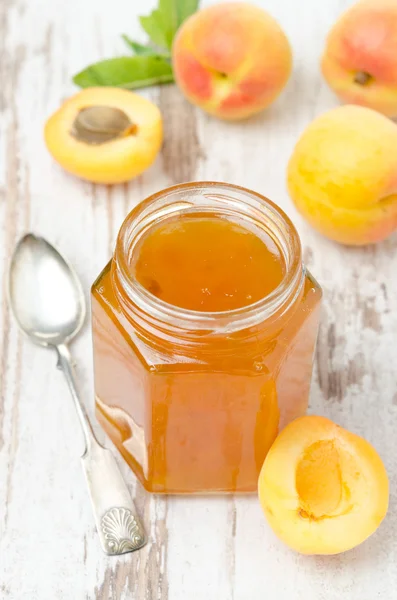 Apricot confiture in a glass jar and fresh apricots, top view — Stock Photo, Image